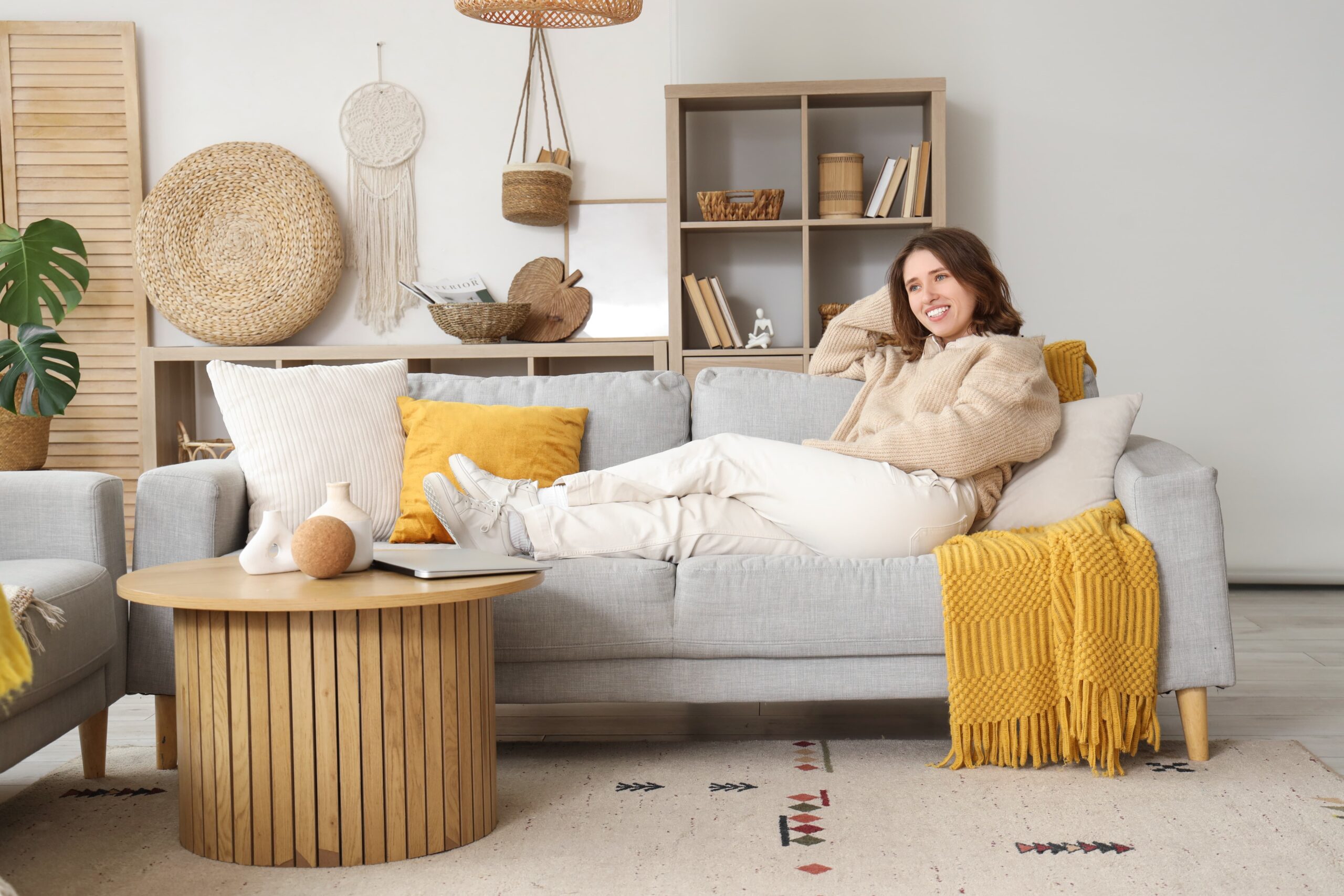 Young woman sitting in her furnished apartment